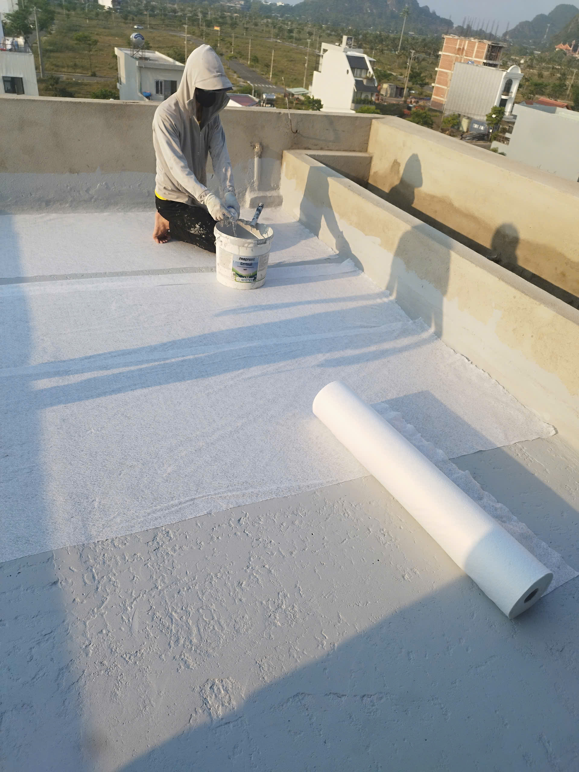 Hình ảnh đội thợ thi công chống thấm sàn mái bằng vật liệu Polyurethane kết hợp lưới Neotextile theo quy trình 5 lớp, đảm bảo độ bền và khả năng chống thấm tuyệt đối.